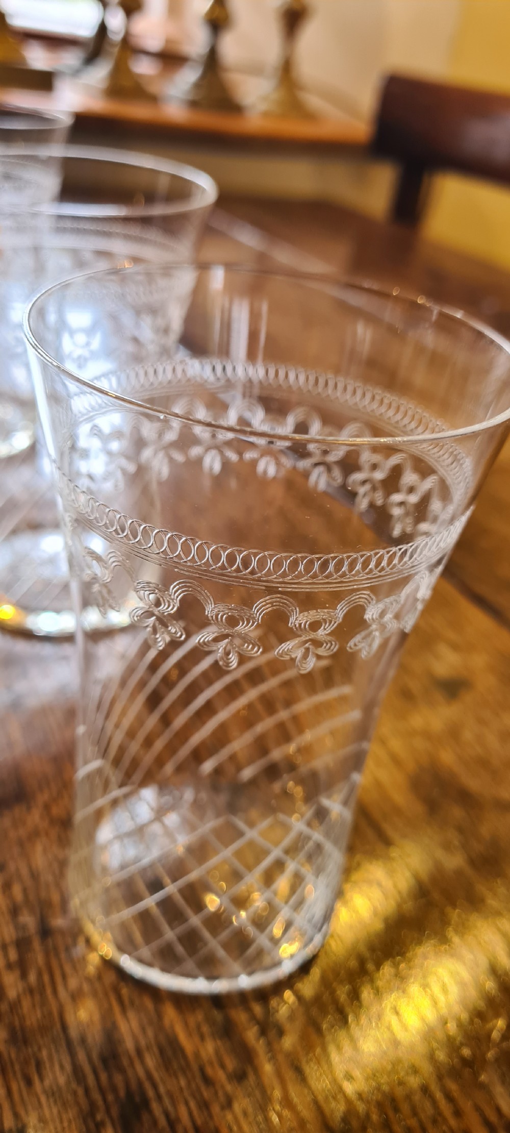 A twelve-piece set of clear Edwardian glass cordial tumblers with etched lattice and foliate bands. View V