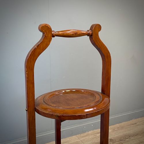 fig 1. An antique three-tier folding mahogany cake stand with circular platforms, a top carrying handle, and splayed feet.