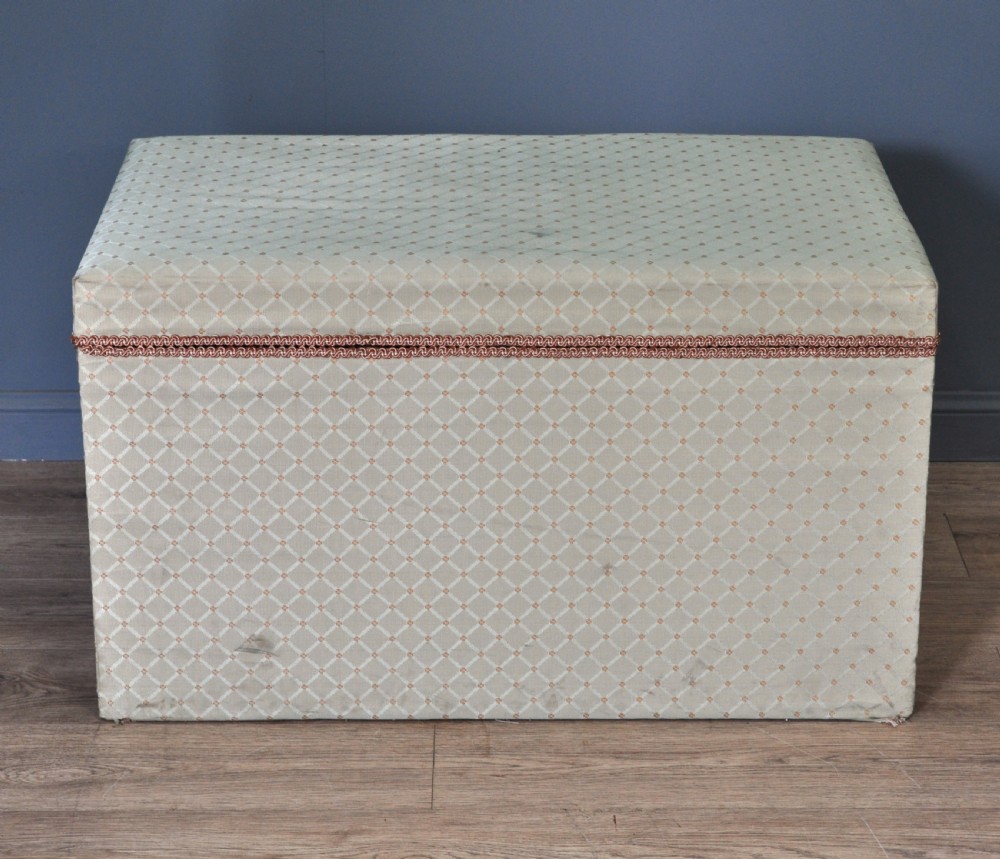 A rectangular Victorian blanket box upholstered in cream lattice-patterned fabric featuring terracotta braid trim around the lid edge. View II