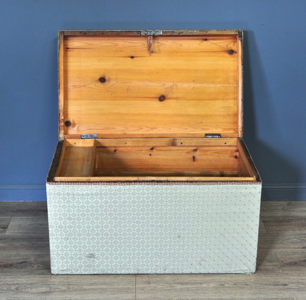 A rectangular Victorian blanket box upholstered in cream lattice-patterned fabric featuring terracotta braid trim around the lid edge. View III
