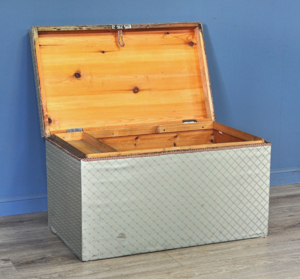 A rectangular Victorian blanket box upholstered in cream lattice-patterned fabric featuring terracotta braid trim around the lid edge. View IV