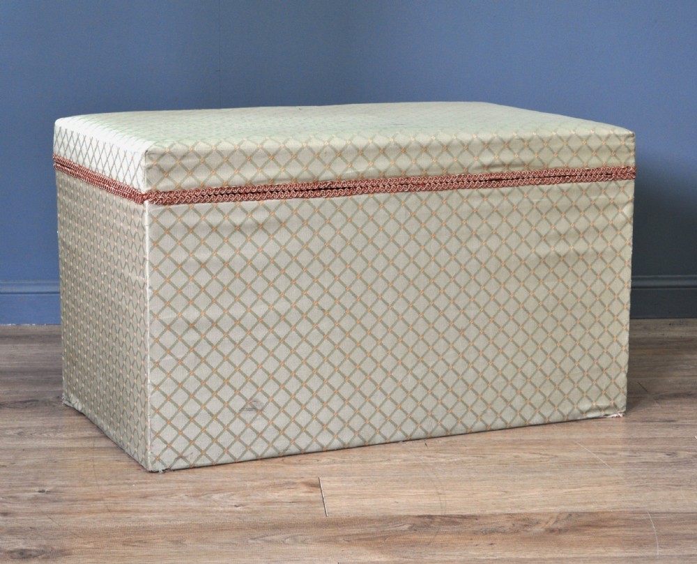 A rectangular Victorian blanket box upholstered in cream lattice-patterned fabric featuring terracotta braid trim around the lid edge. View X