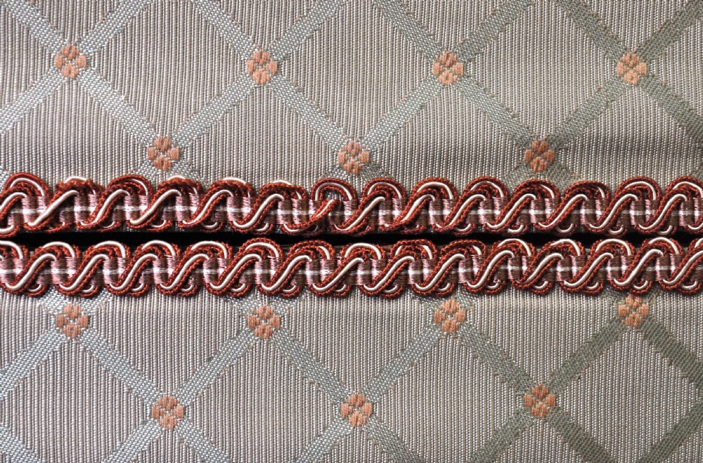 A rectangular Victorian blanket box upholstered in cream lattice-patterned fabric featuring terracotta braid trim around the lid edge. View XIV