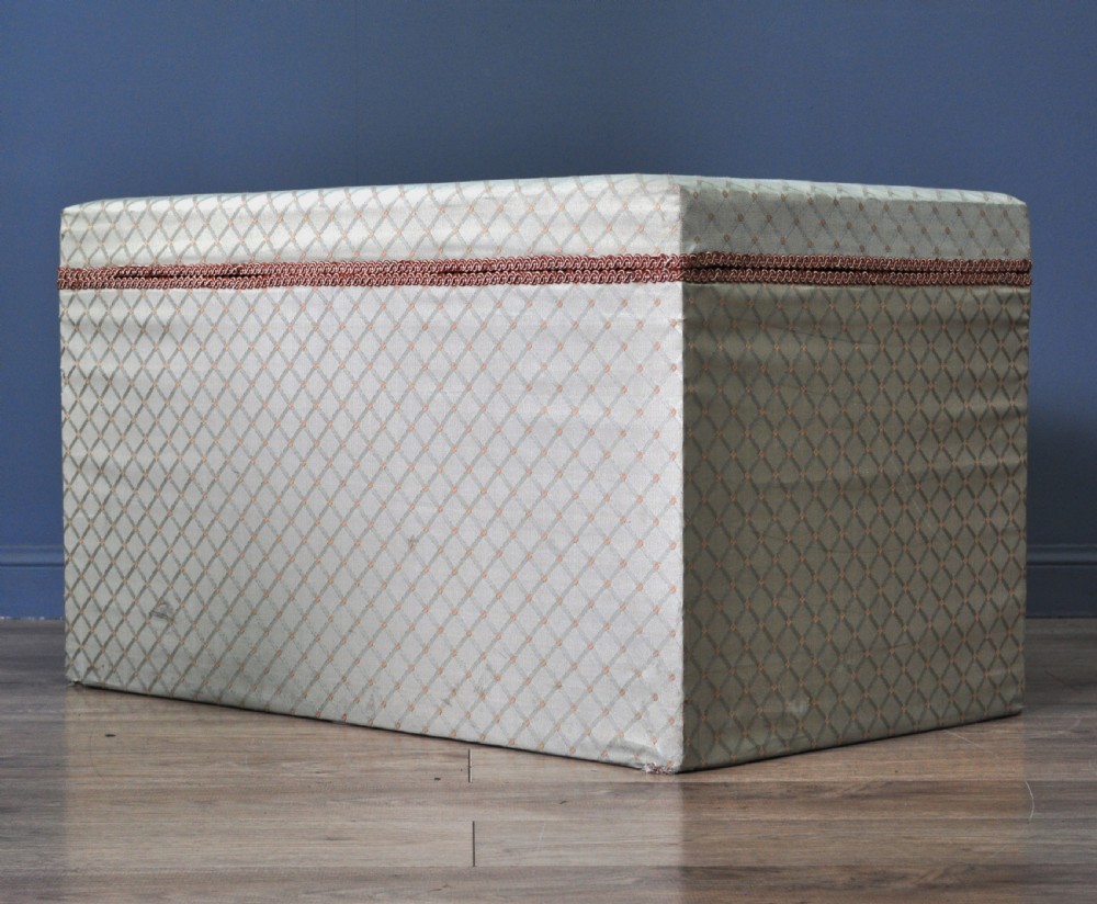 A rectangular Victorian blanket box upholstered in cream lattice-patterned fabric featuring terracotta braid trim around the lid edge. View XV