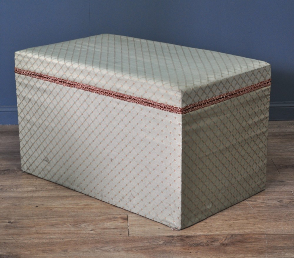 A rectangular Victorian blanket box upholstered in cream lattice-patterned fabric featuring terracotta braid trim around the lid edge. View XVII