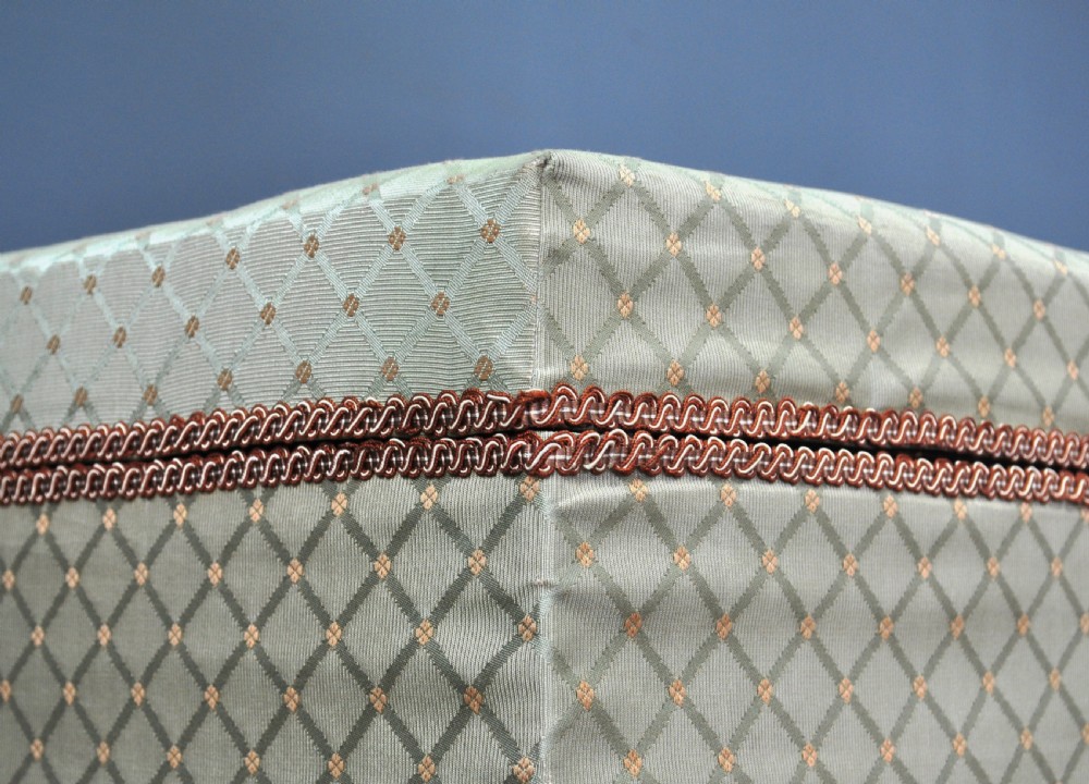 A rectangular Victorian blanket box upholstered in cream lattice-patterned fabric featuring terracotta braid trim around the lid edge. View XVIII