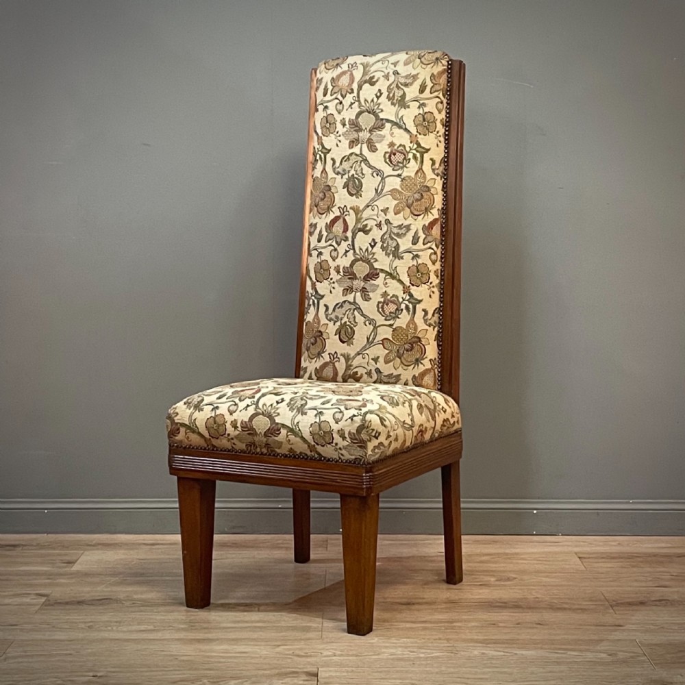An antique walnut nursing chair featuring a tall rectangular backrest, floral upholstery, stud trim, and tapered wooden legs. View II