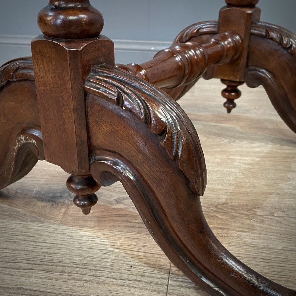 A Victorian mahogany fire screen featuring bobbin-turned uprights, carved feet, and a framed needlework panel displaying a floral bouquet. View VI