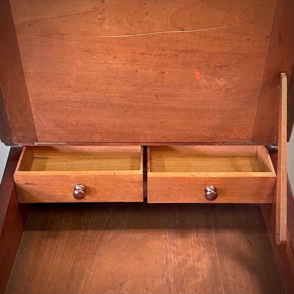 A William IV mahogany Davenport desk featuring a sloped leather writing slope, turned spindle gallery top, side drawers, and brass castors. View V