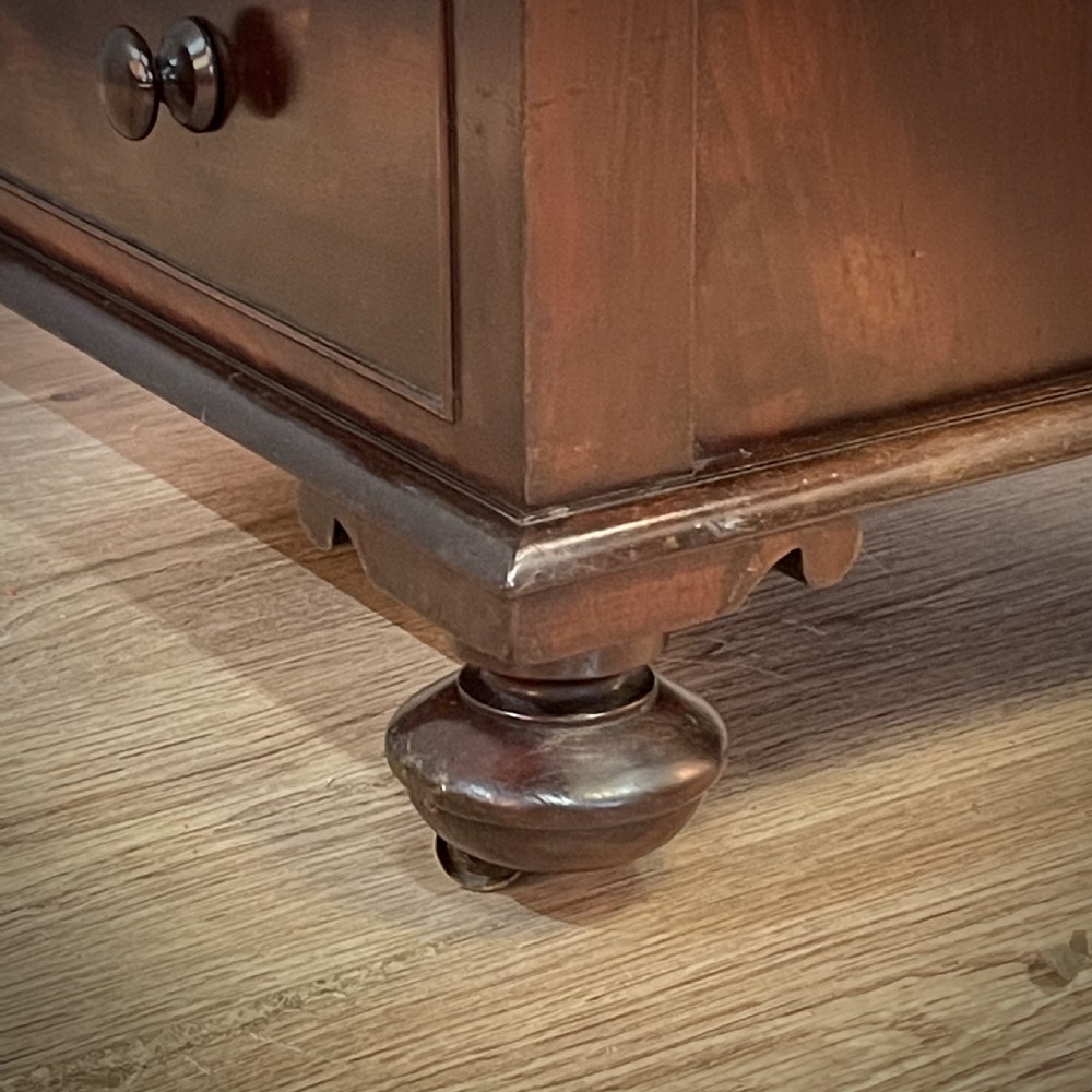 A William IV mahogany Davenport desk featuring a sloped leather writing slope, turned spindle gallery top, side drawers, and brass castors. View XII