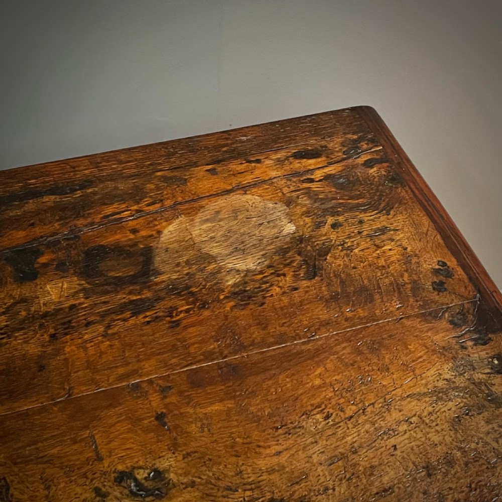 An antique dark oak livery cupboard featuring a carved pierced ventilation panel, central arch motif, turned legs, and a lower stretcher base. View XVI
