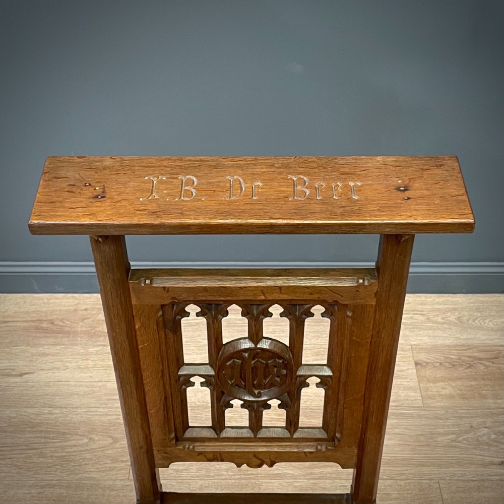 A carved oak Gothic Revival chair featuring a traceried back panel, leather studded seat, and turned stretchers. View IV