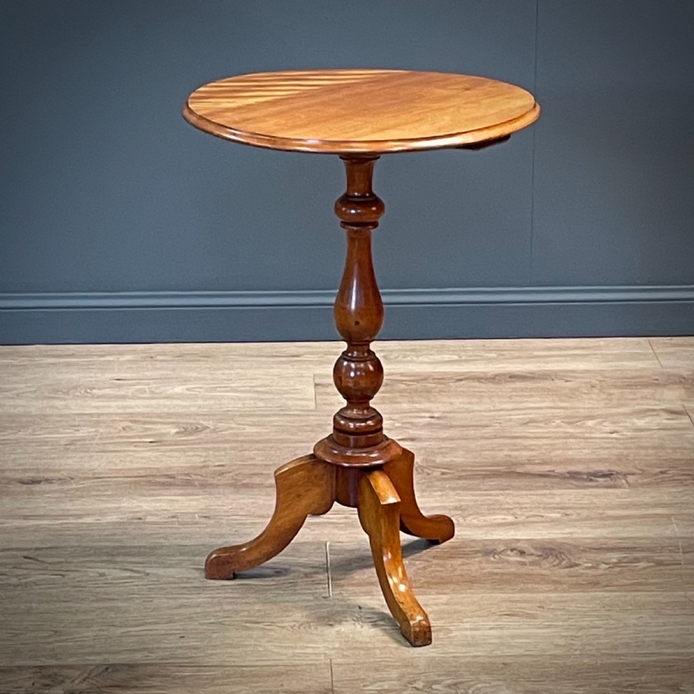 A Victorian circular satin birch occasional table featuring a turned central column supported by a tripod base with splayed legs.