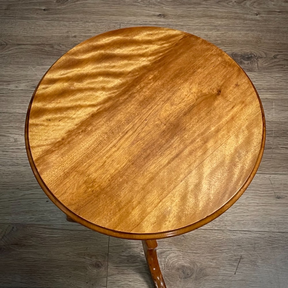 A Victorian circular satin birch occasional table featuring a turned central column supported by a tripod base with splayed legs. View II