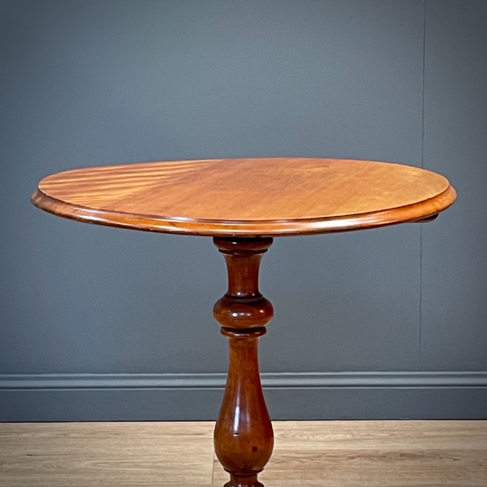 A Victorian circular satin birch occasional table featuring a turned central column supported by a tripod base with splayed legs. View VI