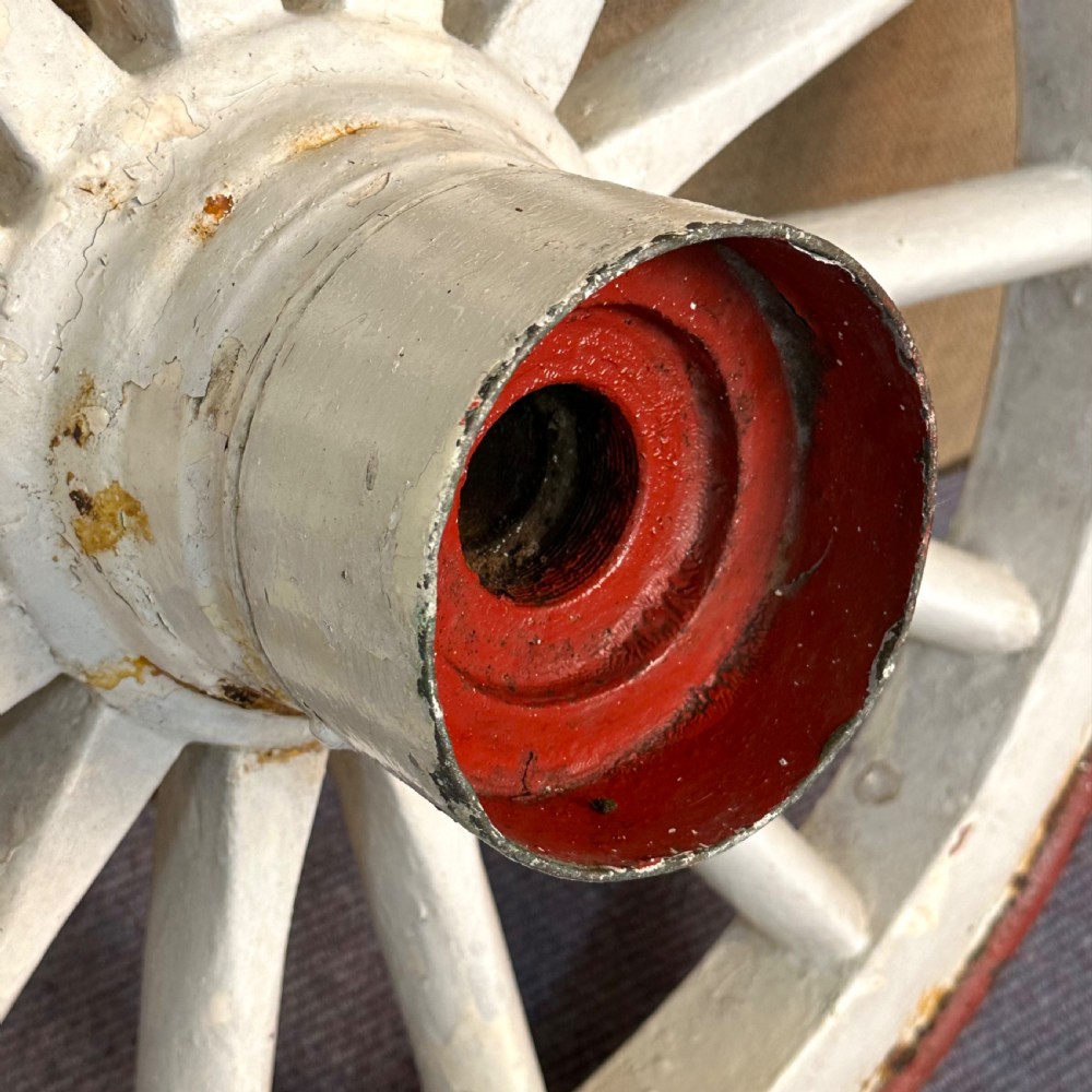 A pair of Victorian wooden cart wheels featuring painted white spokes, red cast iron hubs, and red metal outer rims. View IV