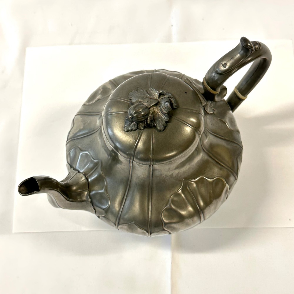 Victorian pewter teapot with a lobed body, curved spout, scrolled feet, and a bud-shaped lid finial. View V