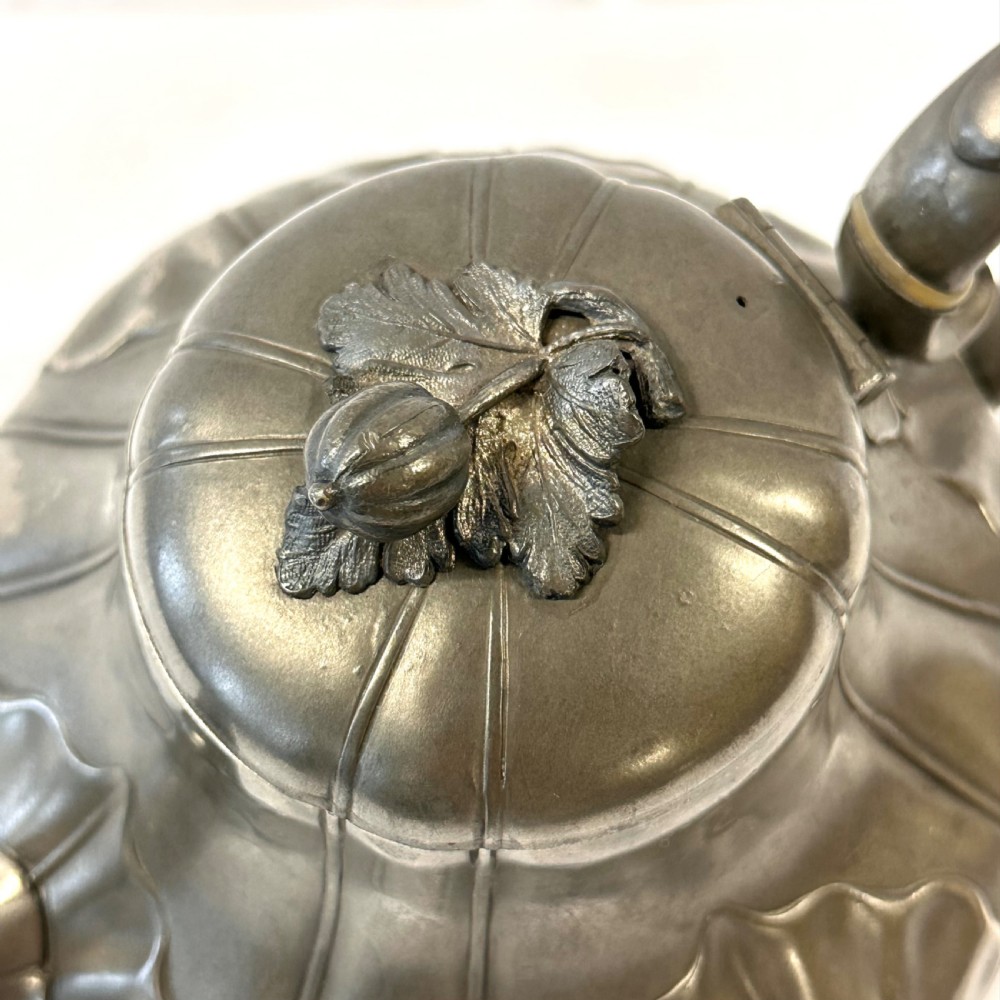 Victorian pewter teapot with a lobed body, curved spout, scrolled feet, and a bud-shaped lid finial. View VI