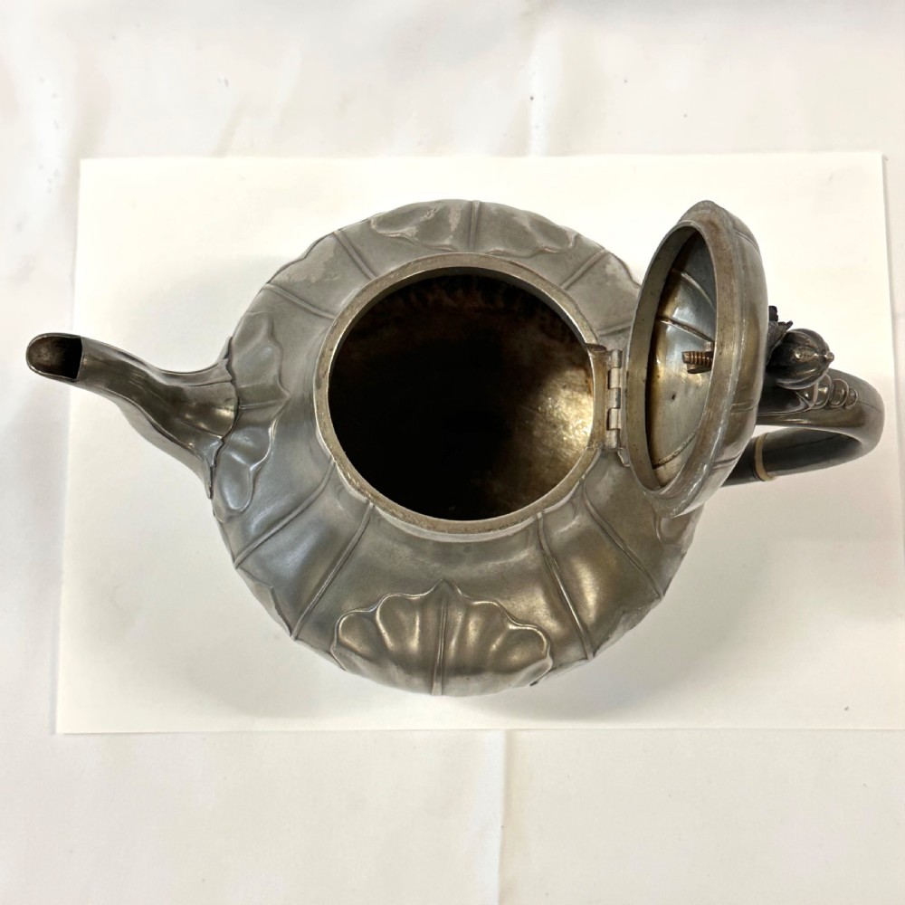 Victorian pewter teapot with a lobed body, curved spout, scrolled feet, and a bud-shaped lid finial. View IX