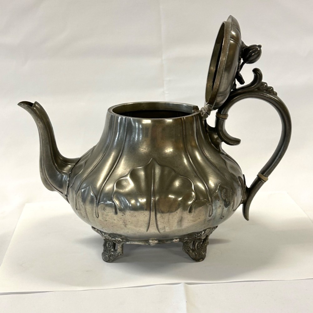 Victorian pewter teapot with a lobed body, curved spout, scrolled feet, and a bud-shaped lid finial. View X