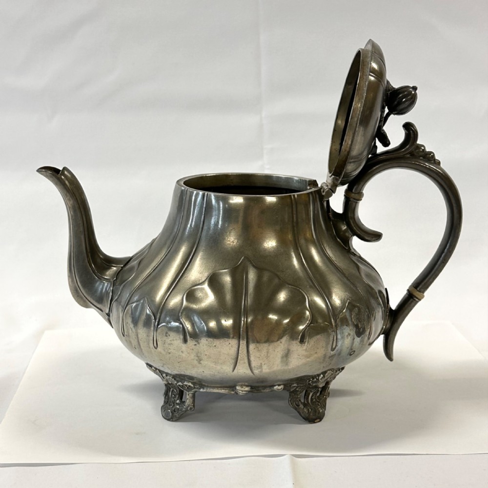 Victorian pewter teapot with a lobed body, curved spout, scrolled feet, and a bud-shaped lid finial. View XV
