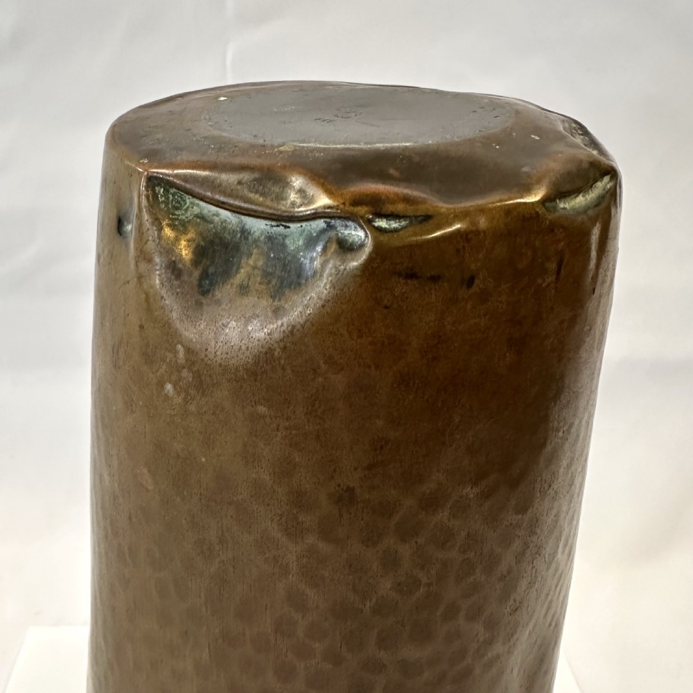 A pair of cylindrical brass vases featuring hand-hammered lower bodies and circular embossed floral medallions around the upper rim. View XI