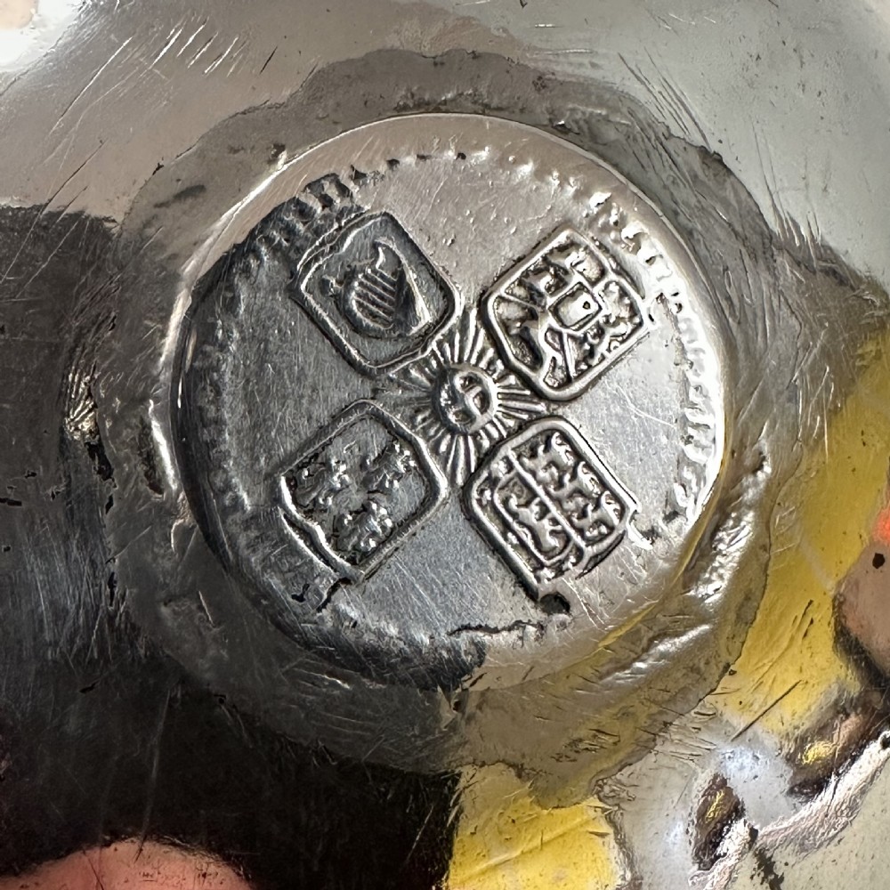 An 18th-century Georgian silver toddy ladle featuring an inset silver coin at the base of the bowl attached to a dark turned handle. View VI