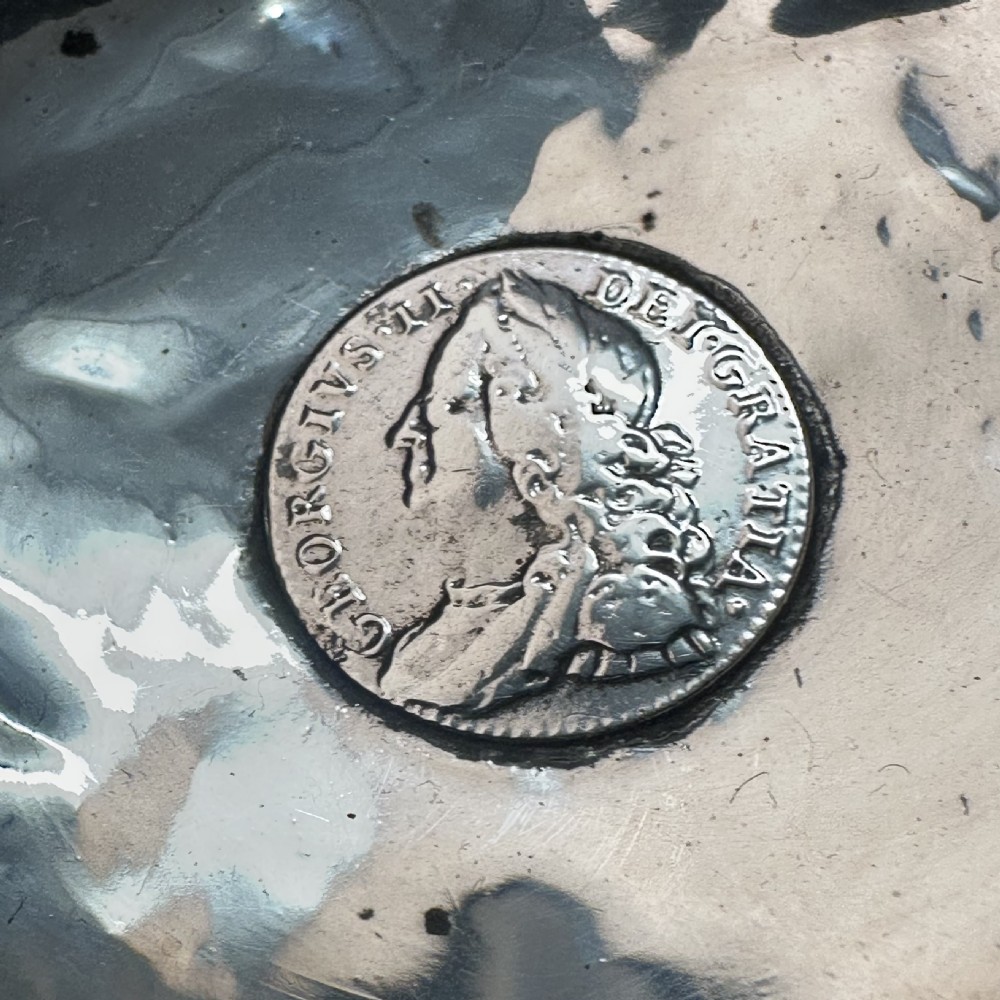 An 18th-century Georgian silver toddy ladle featuring an inset silver coin at the base of the bowl attached to a dark turned handle. View VII