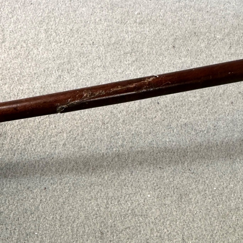 An 18th-century Georgian silver toddy ladle featuring an inset silver coin at the base of the bowl attached to a dark turned handle. View VIII