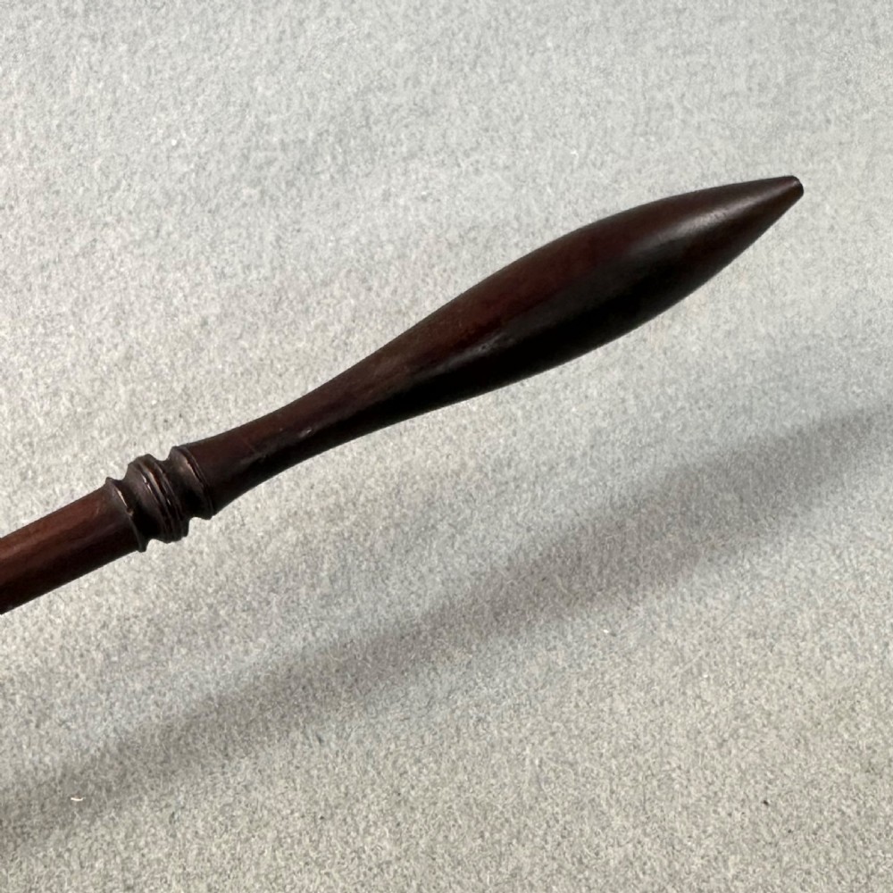 An 18th-century Georgian silver toddy ladle featuring an inset silver coin at the base of the bowl attached to a dark turned handle. View IX
