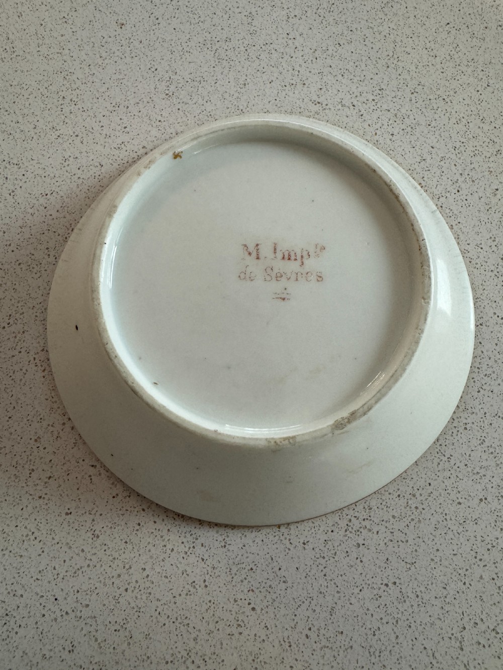 A straight-sided French porcelain coffee cup and saucer featuring hand-painted sepia landscape scenes, a pale yellow ground, and wide gold leaf borders. View VI