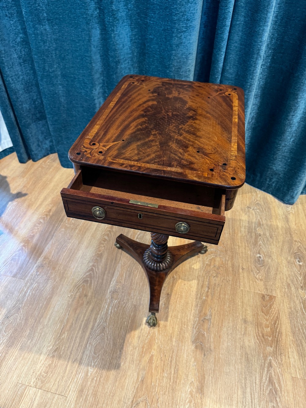 A Regency mahogany occasional table featuring a rectangular inlaid top above a single drawer, supported by a spiral-turned pedestal and a triform base on brass claw feet. View IV