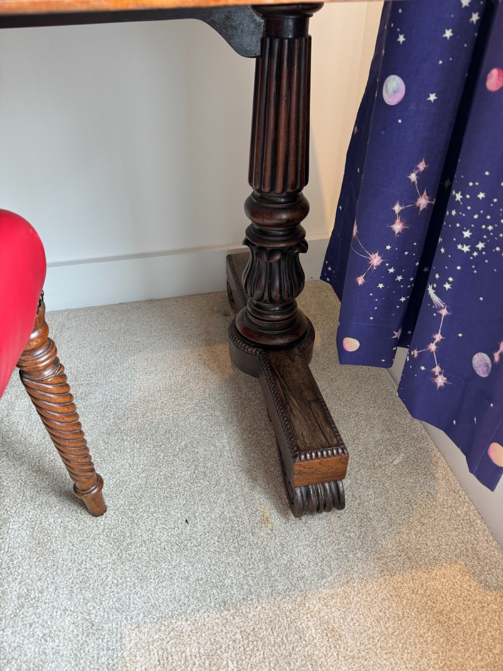 A Regency rosewood writing table featuring a highly figured top, two frieze drawers with brass lion-mask handles, and carved turned pedestal legs on trestle feet. View VI