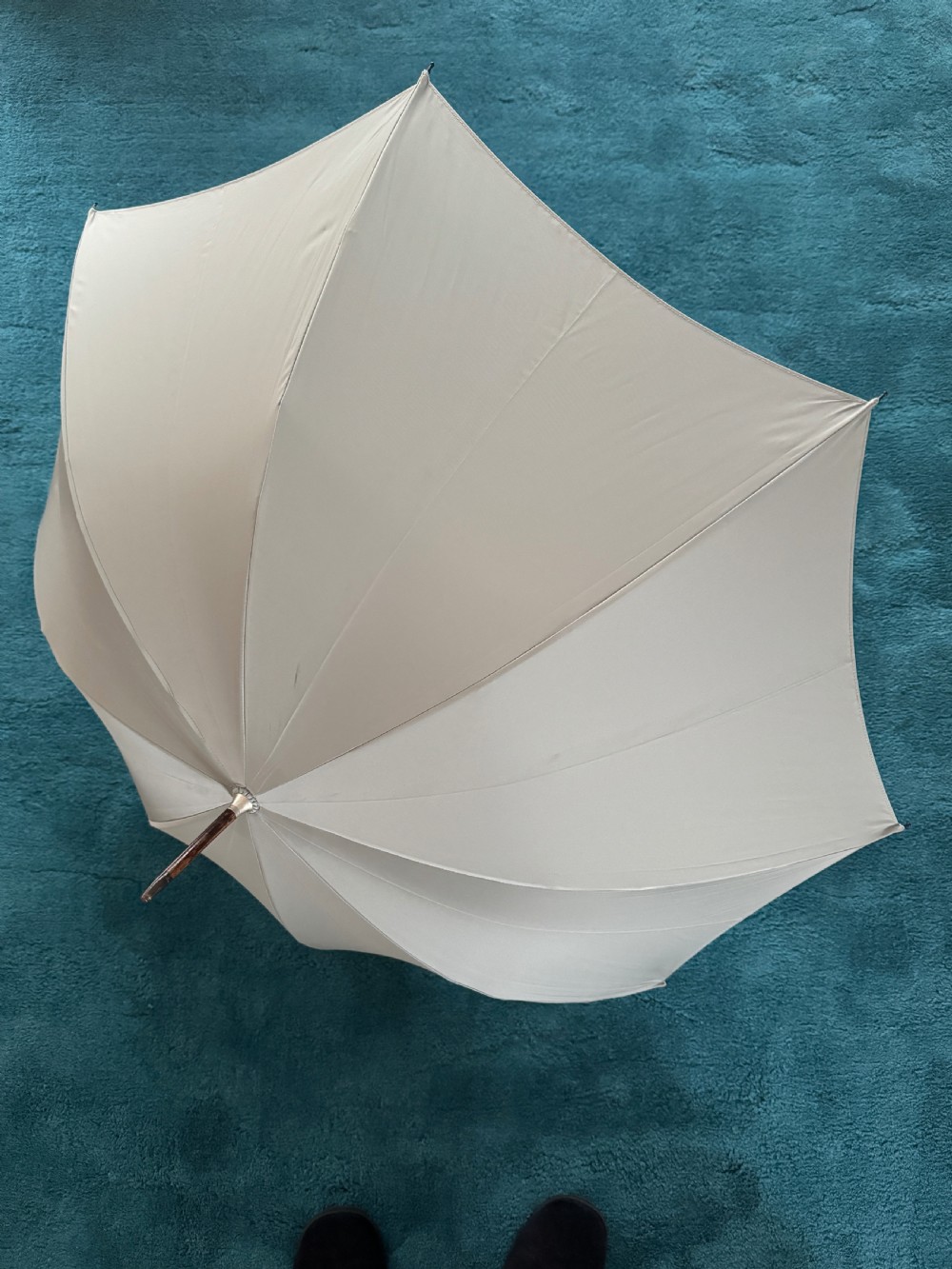 An Edwardian parasol featuring a carved silver duck head handle, a dark wooden shaft, and a folded sage green fabric canopy. View III