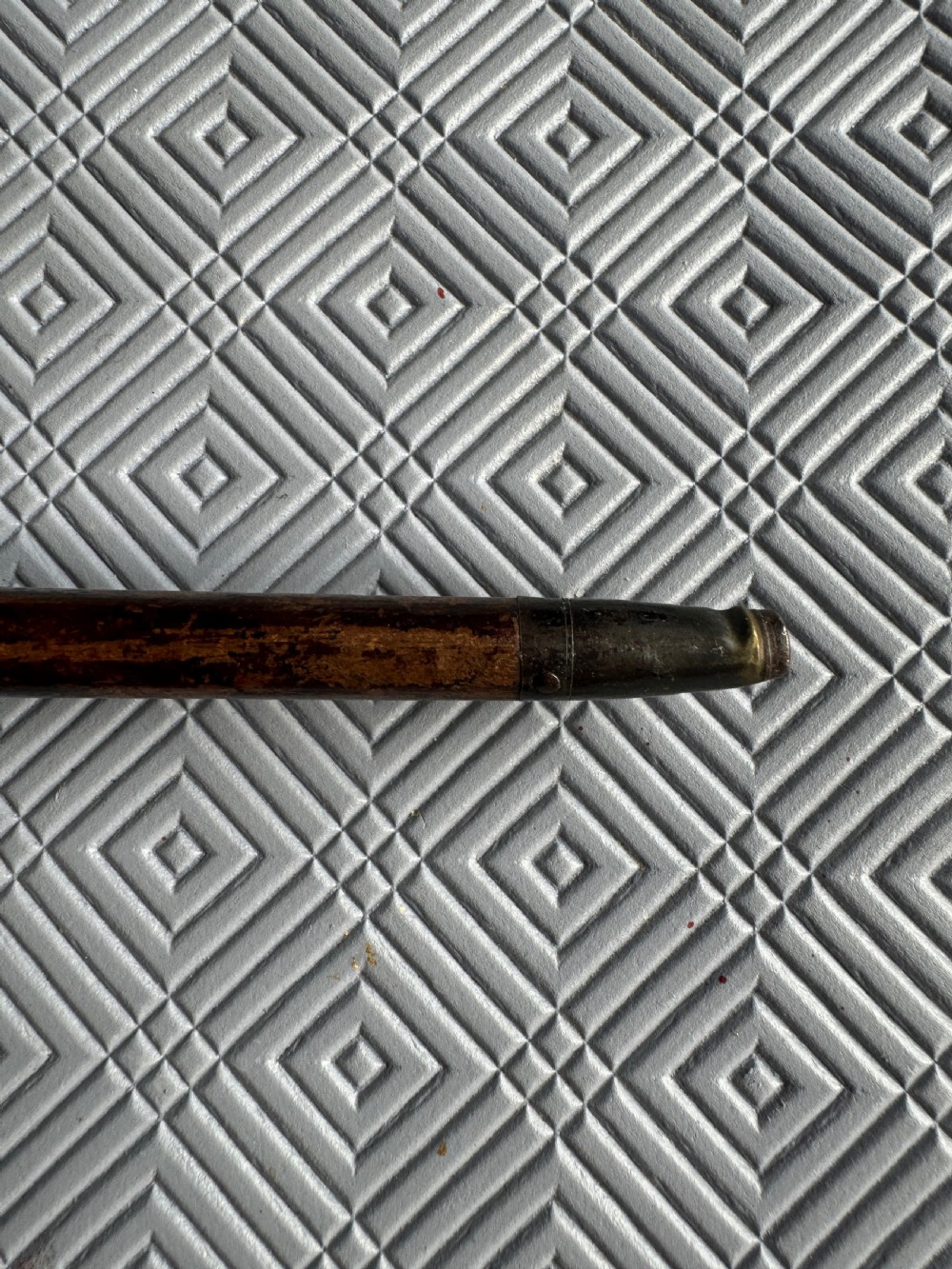 An Edwardian parasol featuring a carved silver duck head handle, a dark wooden shaft, and a folded sage green fabric canopy. View VI