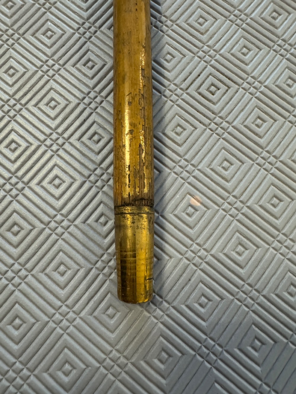 An antique wooden walking stick featuring a rounded cream pommel and an embossed silver collar decorated with a dragon motif. View V