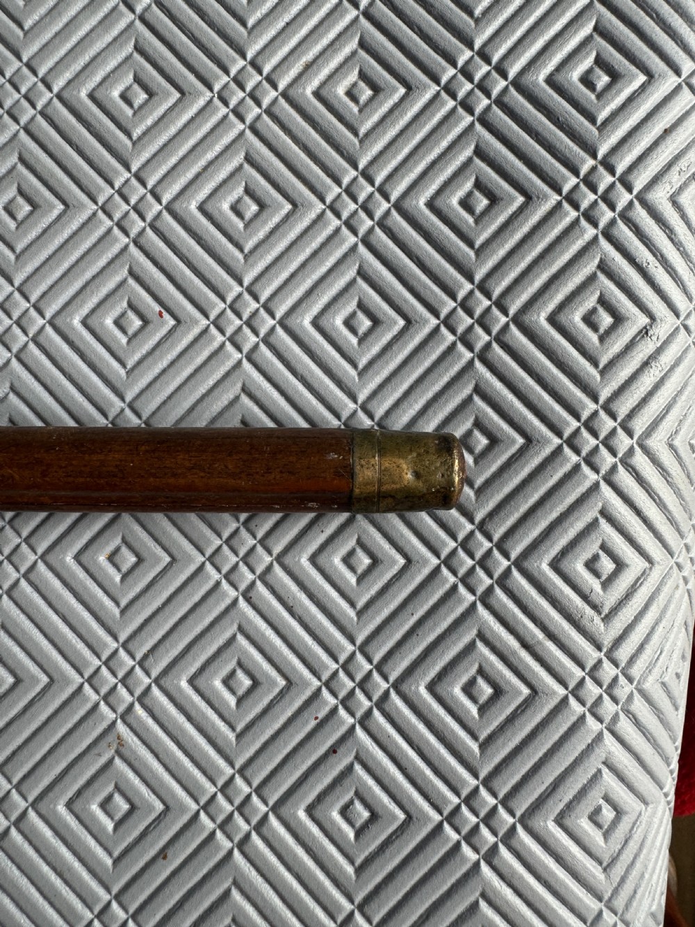 A dark brown bamboo walking stick featuring a cream and gold painted ceramic pommel handle. View IV