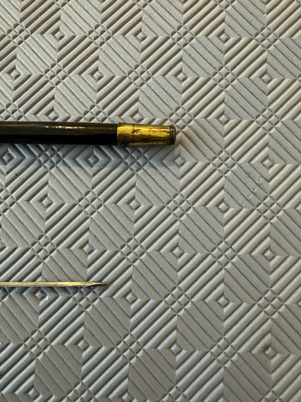 An antique Chinese sword stick featuring a dark wood shaft and an intricately detailed, silver-coloured metal handle decorated with raised figural motifs. View V