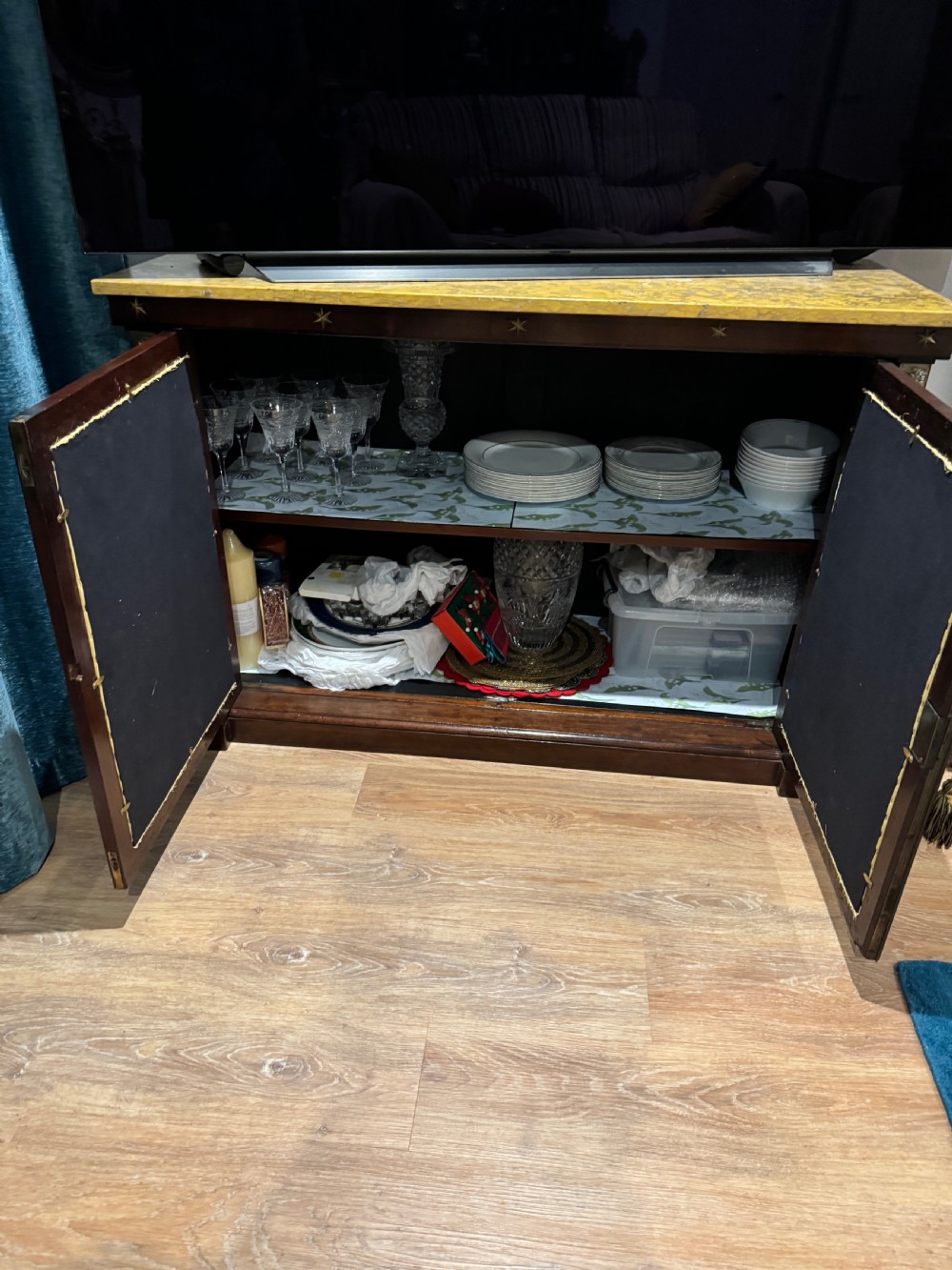 A Regency period dark mahogany side cabinet featuring an original yellow breche marble top, Egyptian revival gilt bronze mounts, and brass wire grille doors with pleated silk backing. View VI