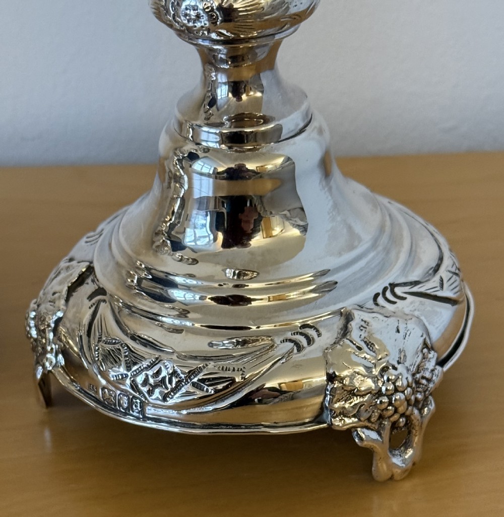 A pair of tall, polished sterling silver Shabbat candlesticks featuring ornate knopped stems and repousse foliate bases. View XI