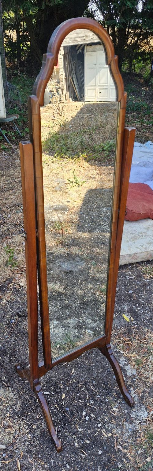 A full-length walnut cheval mirror featuring an arched wooden frame suspended between two vertical uprights on splayed feet. View III