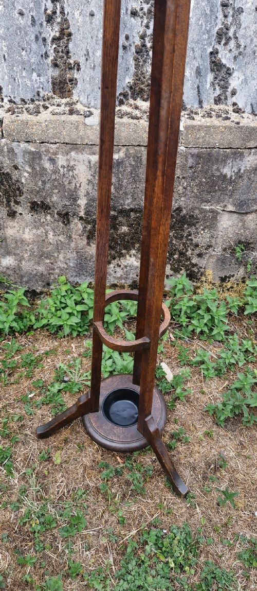 A tall Edwardian dark oak coat stand featuring brass hooks, a turned wooden central column, a lower umbrella retaining ring, and a circular drip tray base. View VIII