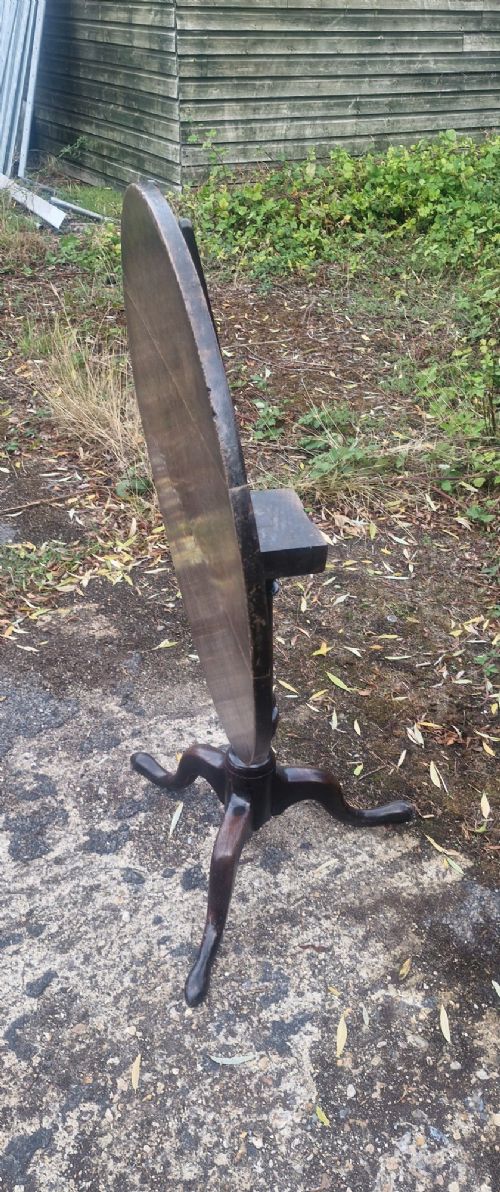 A dark oak 19th-century occasional table featuring a circular top tilted vertically on a turned pedestal with three cabriole legs. View III