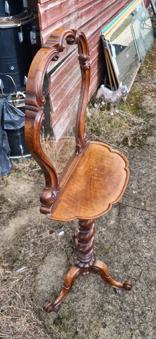 A Victorian walnut pedestal table featuring a shaped tabletop, an ornate carved mirror frame back, a spiral barley twist column, and carved tripod legs. View III