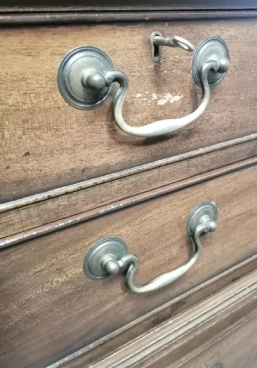 A three-part mahogany campaign style chest of drawers featuring brass handles, side carrying brackets, and bracket feet. View IV