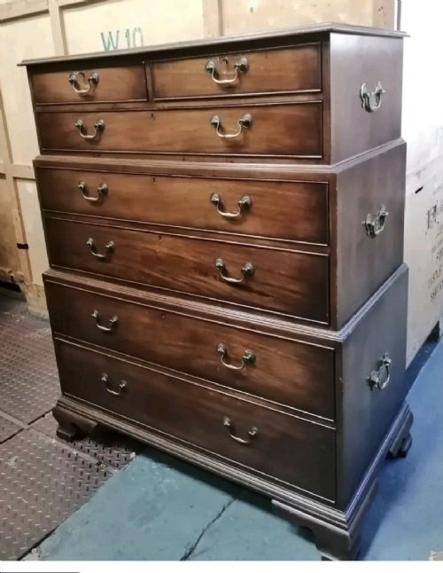 A three-part mahogany campaign style chest of drawers featuring brass handles, side carrying brackets, and bracket feet. View V