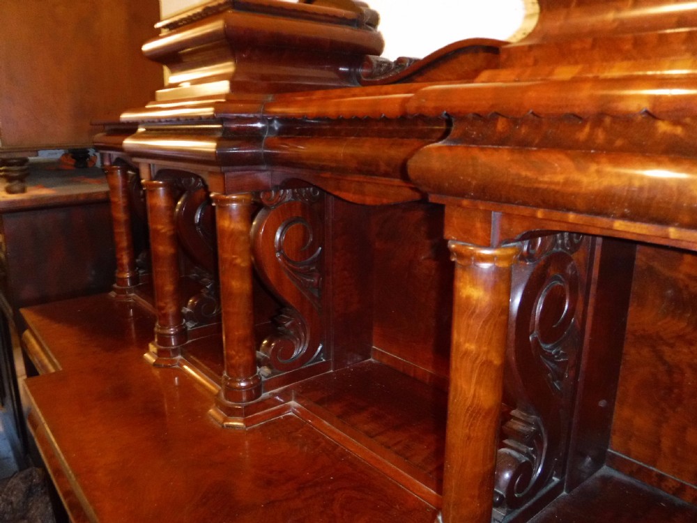 A large Regency mahogany side cabinet featuring turned support columns, panelled cupboard doors, and a tier of raised shelves. View VII