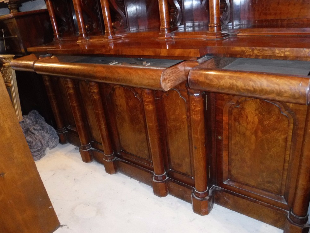 A large Regency mahogany side cabinet featuring turned support columns, panelled cupboard doors, and a tier of raised shelves. View XI