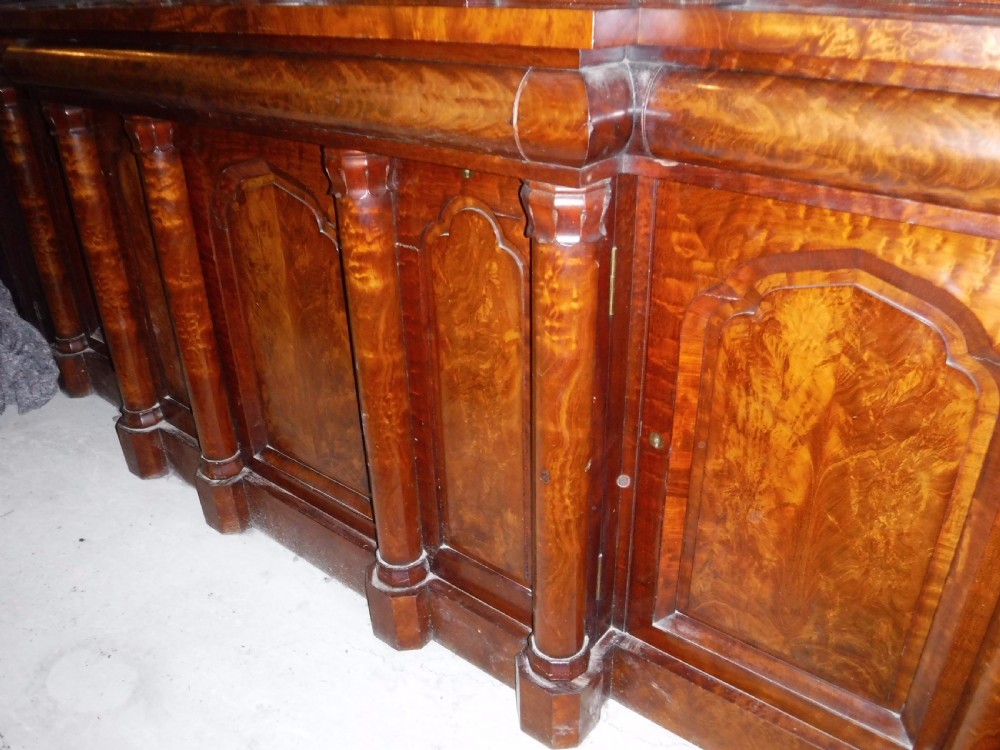 A large Regency mahogany side cabinet featuring turned support columns, panelled cupboard doors, and a tier of raised shelves. View XII