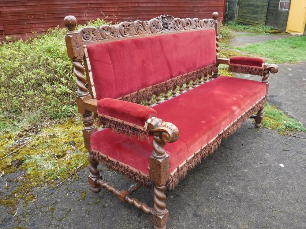 A late nineteenth-century carved oak hall bench featuring red velvet upholstery with fringe trim and barley twist legs. View II